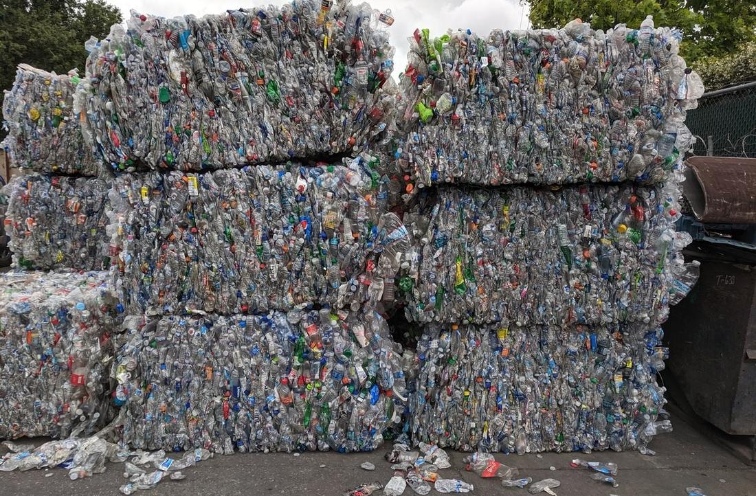Bales of used PET bottles stacked at a recycling yard